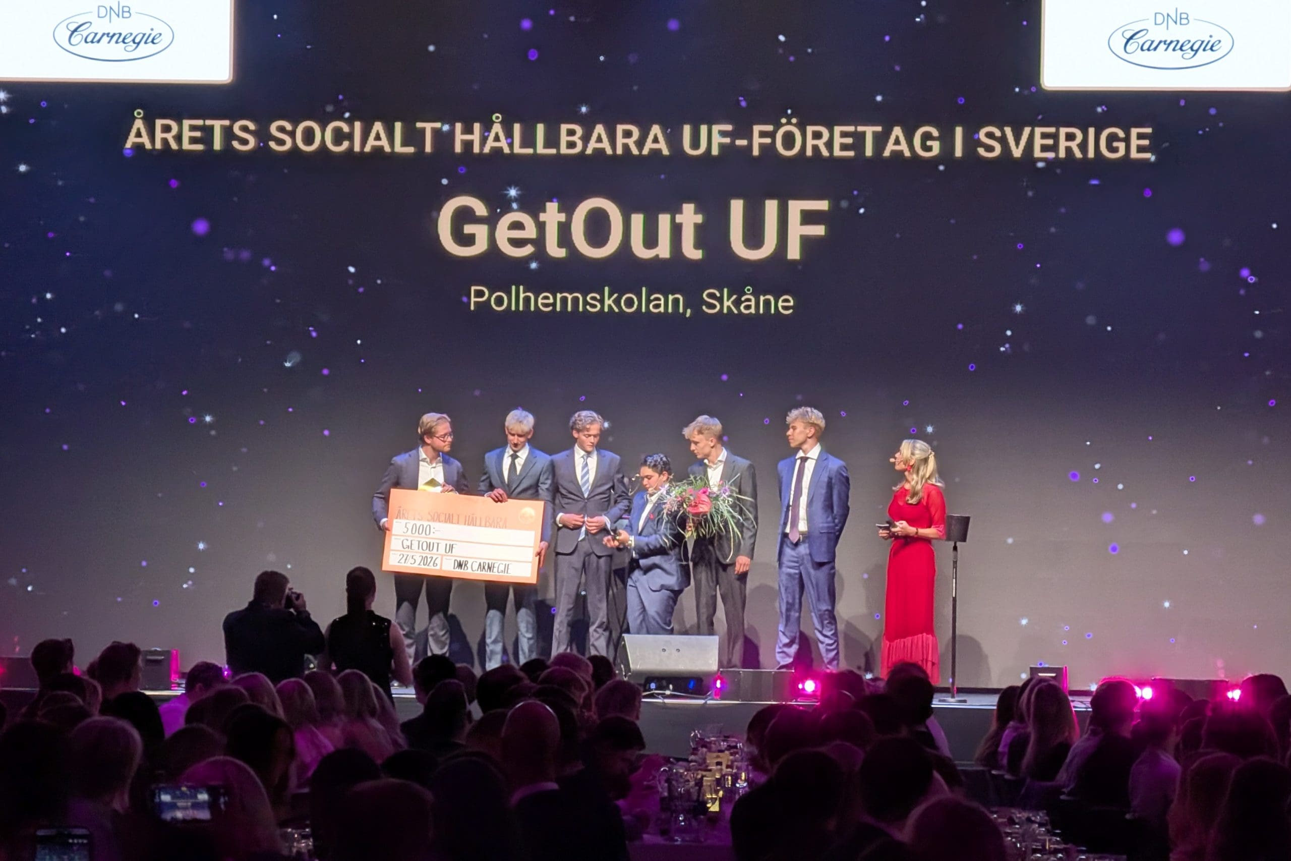 GetOut UF står uppe på scenen och tar emot sitt pris för Årets socialt hållbara UF-företag.